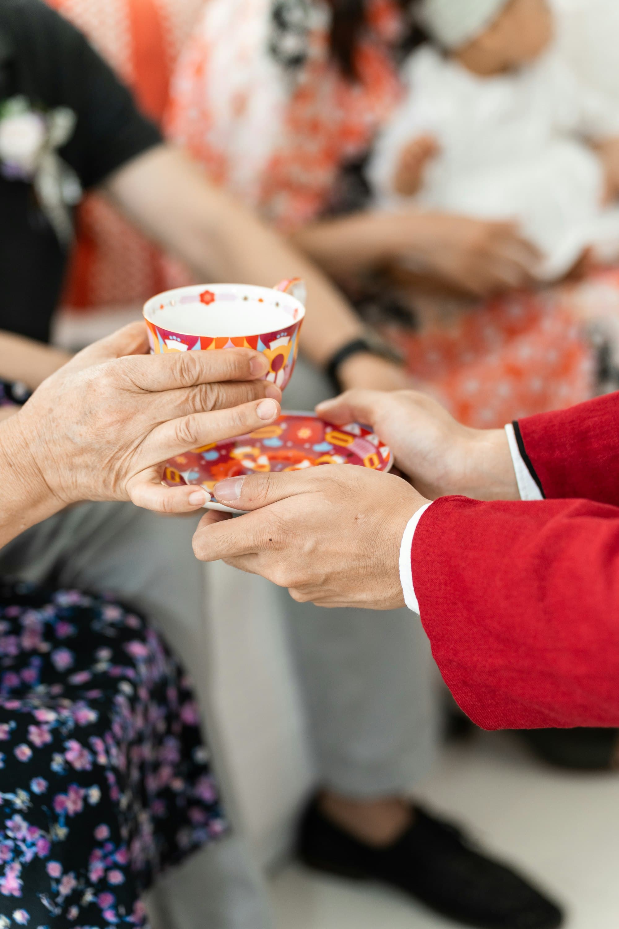 A cup of tea being handed to an older person